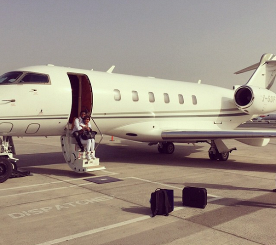 Samuel Eto'o and wife sit on the step of their private jet