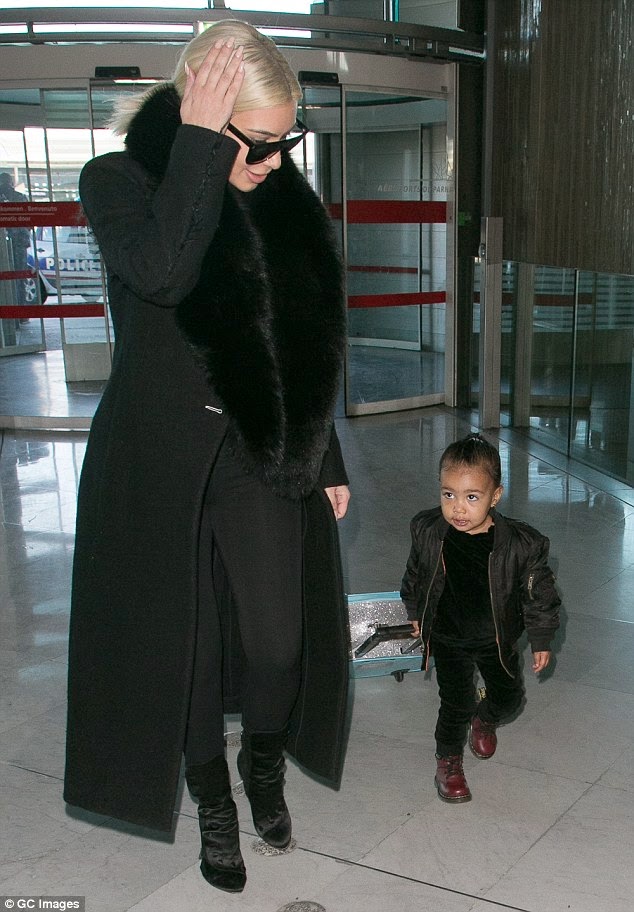 North West amazing in this photo as she handles her own suitcase